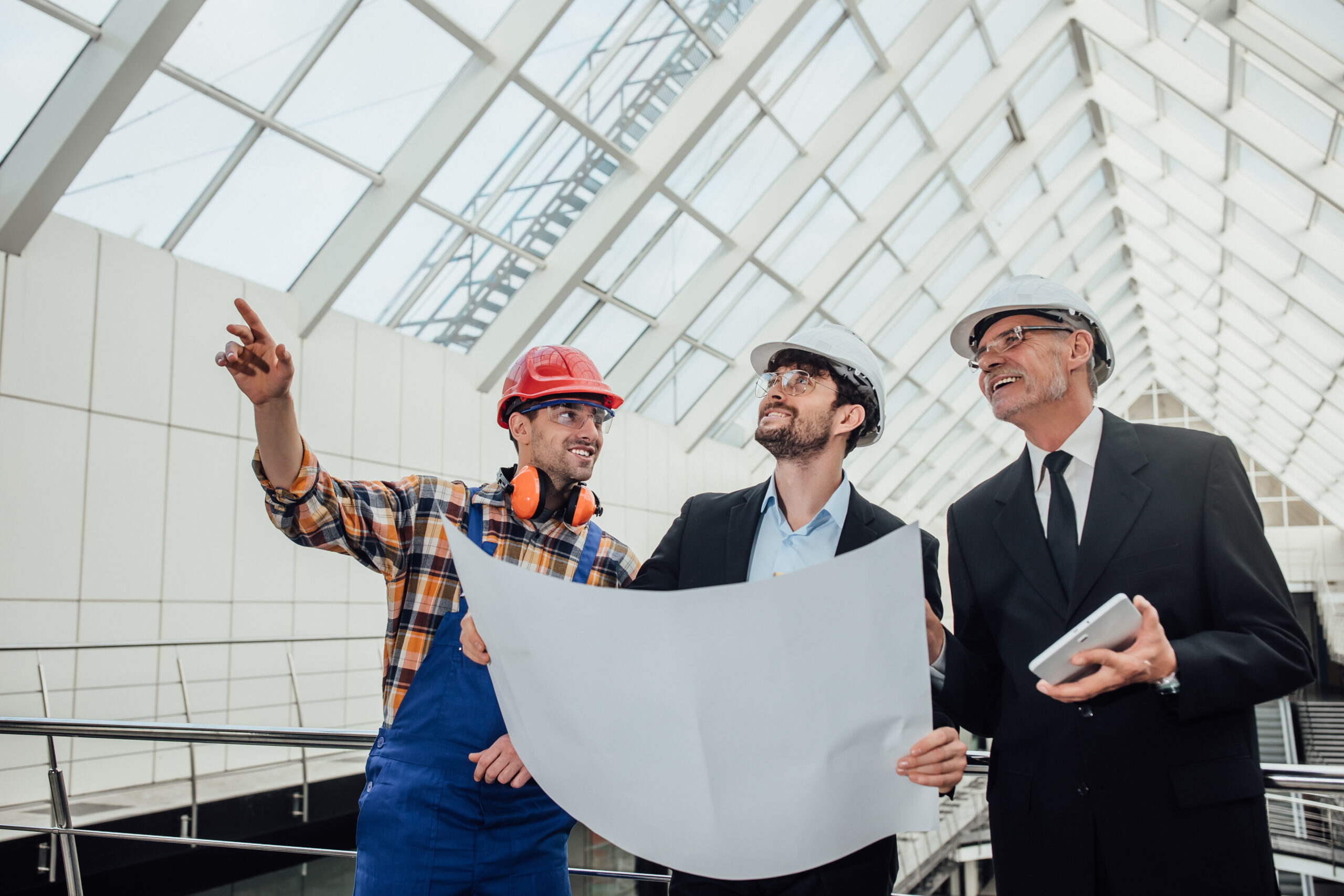 Portrait of two successful architects and foreman discussing the design of the project.